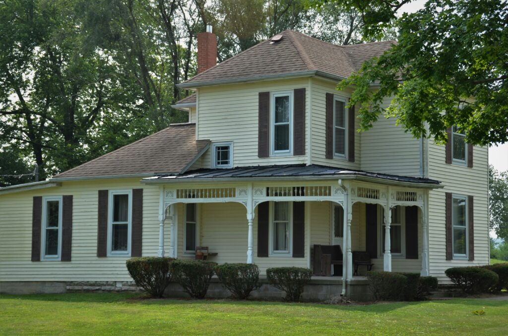 white and brown wooden house near green trees