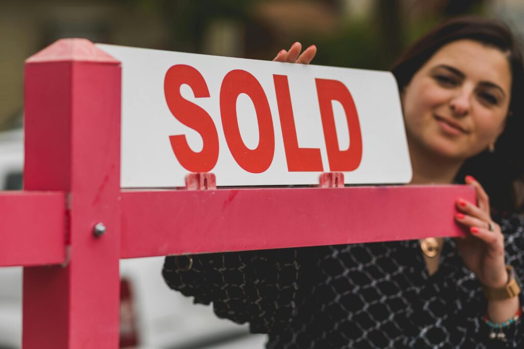real estate agent holding a sold sign